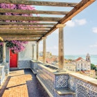 Lisbon city roofs in Portugal
1392686675
tram, rua augusta arch
A view of the rooftops of Lisbon from a terrace decorated with blue tiles